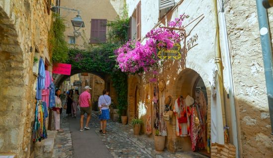 Charming European boutique street with pink flowers and elegant shop fronts